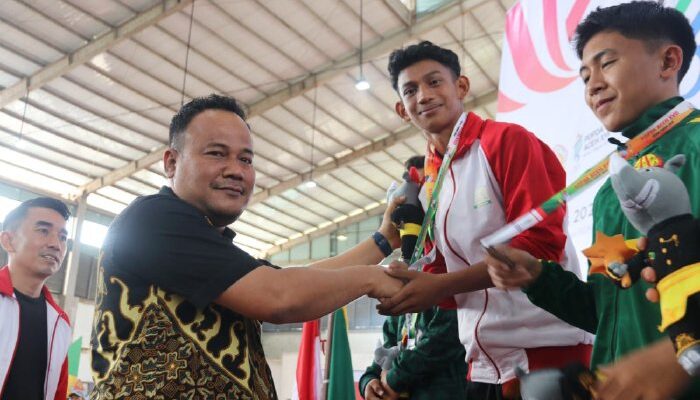 Pj. Sekda Aceh Timur Mengalungkan Medali Emas Cabor Pencak Silat